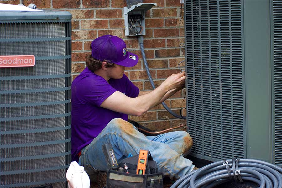 Technician completing AC repair in Raleigh NC outdoors