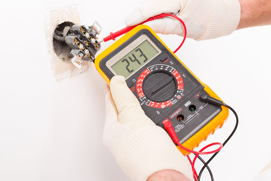 Technician using clamp meter to test HVAC furnace wiring